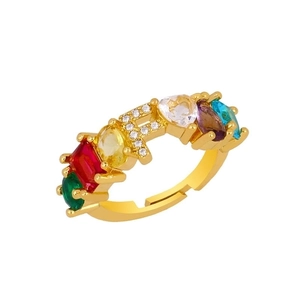 Detail of adjustable gold ring with colorful gemstones and pavé zircon letter F