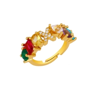 Detailed macro shot of adjustable gold ring with rainbow gemstones and diamond X letter
