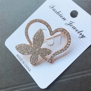 Detailed view of heart butterfly brooch with sparkling crystals on rose gold finish