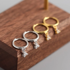 Detail view of silver and gold S925 sterling silver hoop earrings with clover charms