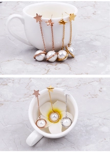 Detailed view of titanium star and pearl earrings in gold, rose gold and silver finishes