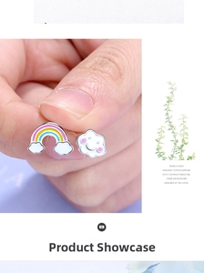 Dettaglio macro di orecchini asimmetrici con arcobaleno e nuvola con smalto