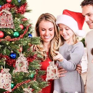 Family decorating Christmas tree with numbered cotton drawstring gift bags set