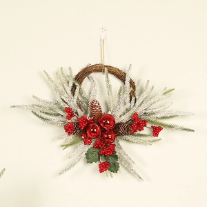 Detail of Christmas wreath with frosted pine needles, red berries, cones and bells