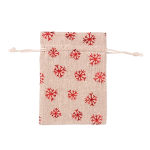 Close-up of beige cotton drawstring bag featuring a red metallic snowflake pattern