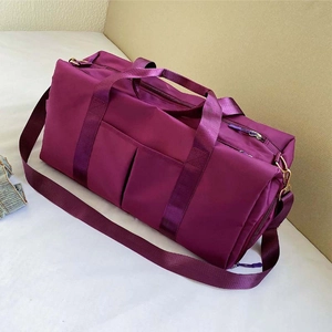Detail view of large purple travel bag showing sturdy nylon fabric and adjustable strap