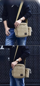 Detail view of khaki canvas crossbody bag featuring a dedicated drawstring water bottle pocket