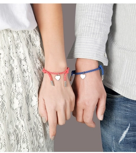Matching red and blue woven bracelets for couples featuring heart-shaped metal charms
