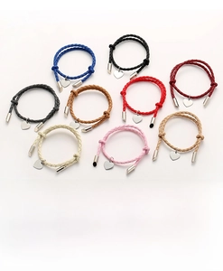Flat lay of woven braided couple bracelets in nine vibrant colors with heart charms