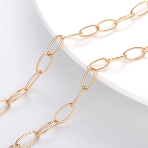 Macro detail of polished gold-plated large oval link chain with minimalist metal finish