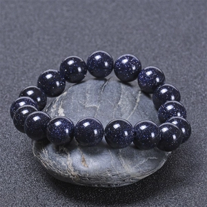 Deep blue sandstones bracelet on natural rock, showing shimmering star-like textures