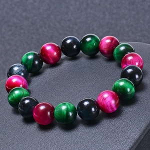 Bracelet en œil de tigre poli avec perles vertes, roses et bleues sur fond sombre