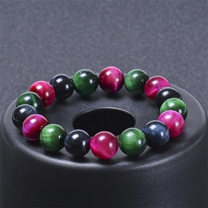 Vue macro de perles d'oeil de tigre multicolores avec chatoyance sur un support noir