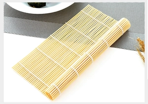 Detailed close-up of a natural bamboo sushi rolling mat with fine woven cotton threads