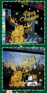 Close-up of golden glitter Christmas window stickers featuring cartoon elk and bear designs