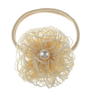 Detail of beige nylon baby headband featuring a large mesh flower with faux pearl