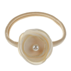 Detailed view of baby nylon headband featuring cream fabric flower and center pearl decor