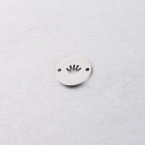 Close-up of a stainless steel circular pendant featuring a crown cutout and two small holes