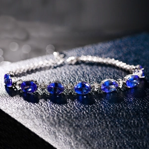 Macro shot of silver bracelet with oval-cut blue gemstones in high-quality prong settings