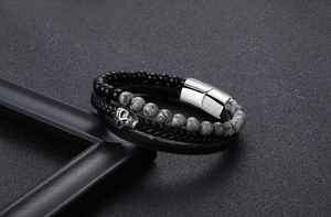 Detail of multilayer men's leather bracelet with black agate, marble beads, and silver skull