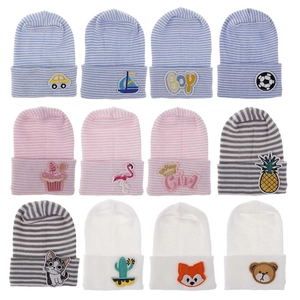 Set of 12 newborn baby knitted beanies with various cartoon embroidery on white background