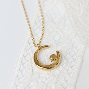 Macro shot of 18K gold plated crescent moon pendant with sparkling claw-set cubic zirconia