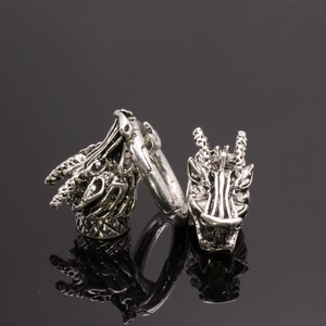 Vue détaillée de breloques tête de dragon en argent rétro sur une surface miroir noire