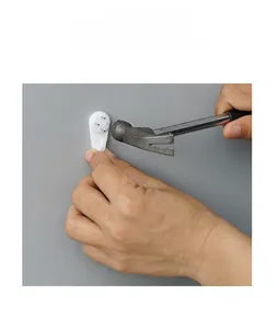 Demonstration of installing white plastic seamless wall hooks using small steel nails