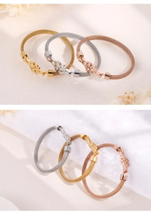 Detailed macro view of woven wire mesh bracelets with clover charms in gold, silver and rose gold