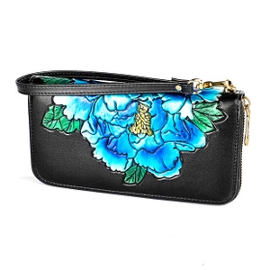Detail of long black leather wallet featuring vibrant blue embossed floral pattern