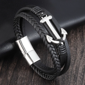 Macro detail of men's leather anchor bracelet with silver clasp and braided texture