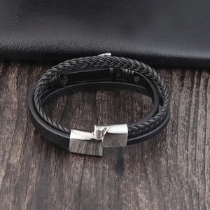Close-up of black braided leather men's bracelet with a silver geometric metal clasp