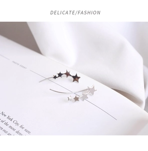 Macro shot of silver star drop earrings featuring five stars in a curved linear design