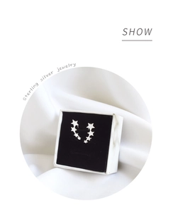 Close-up of sterling silver star-shaped crawler earrings in a black velvet jewelry box