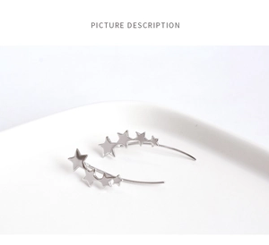 Macro detail of silver S925 star ear climbers with sparkling graduated pentagram shapes