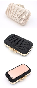 Detail view of pleated evening clutch with rhinestone bow clasp and gold metal frame