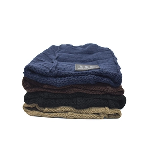 Close-up of four-color rib-knit beanies showing thick texture and decorative patches