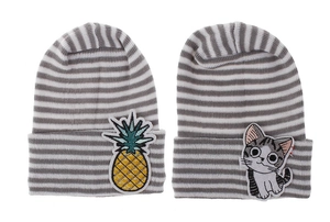 Detail of grey striped baby beanies featuring cute pineapple and cat embroidery patches