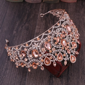 Close-up of rose gold Baroque crown with amber gems and rhinestones on a vintage background