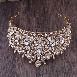 Detailed top view of golden Baroque crown with sparkling rhinestones on wood texture
