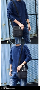 Detail of black canvas shoulder bag with multi-layer zipper pockets and adjustable strap