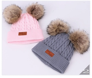 Detailed cable knit texture and faux fur pom-poms on pink and grey children's hats