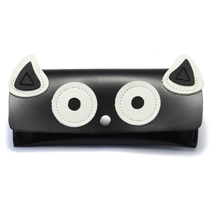 Détail de l'étui à lunettes en forme de chat avec texture cuir noir et blanc et fermoir métal