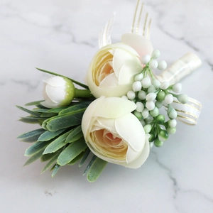 Elegant white tea rose wedding boutonniere with green berries and gold-edged ribbon