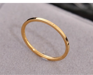 Macro shot of minimalist 18k gold plated thin ring on soft grey velvet background