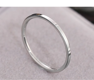 Macro shot of a minimalist slim silver steel ring on soft pink velvet background