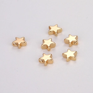 Macro detail of six golden star-shaped DIY beads with side holes for jewelry making