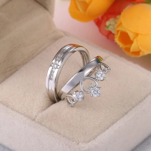 Close-up of crown and cross couple rings with crystals in a velvet jewelry box
