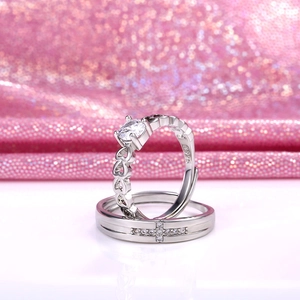 Detailed macro shot of silver couple rings featuring a heart shape and cross design