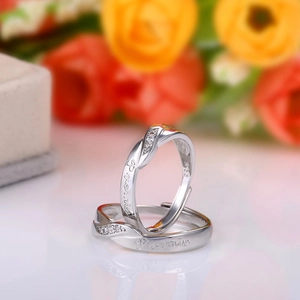 Detail shot of silver promise rings with Her King His Queen engraving and zircon crystals